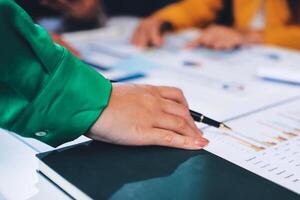 A person is holding a pen and looking at a document photo