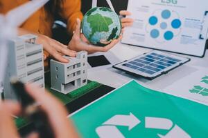 Recycle concept with green building and recycling symbol on table photo