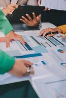 Business people working on a table with graphs and papers photo