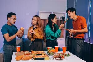 Four people eating pizza and drinking soda at a table photo