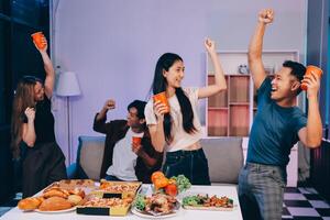 A group of people celebrating with drinks and food photo