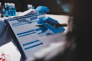 A person in a lab coat is writing on a clipboard photo