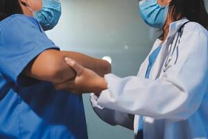 Two doctors shaking hands in an office photo