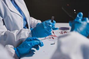 A person in a lab coat and gloves is working on a test tube photo