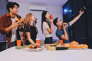 Group of friends enjoying food and drinks at home photo