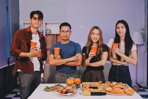 Four people posing for a photo with food