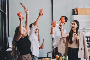 Group of people celebrating with pizza and drinks photo