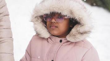 Child enjoying winter weather in a snowy outdoor setting video