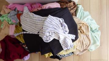 Sorting colorful piles of clothes in a modern home video