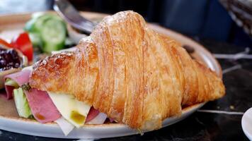 Enjoying a fresh croissant with assorted toppings at brunch video
