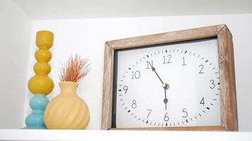Decorative elements on a shelf featuring a clock and vases video