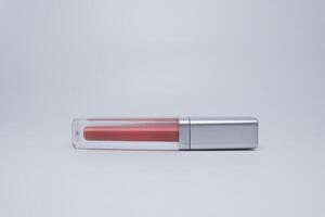 A lipstick with a clear lid on a white surface photo