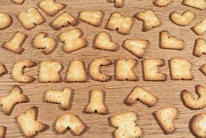 Cracker cookies in the shape of the letters on a wooden surface photo
