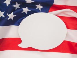 Top view of a blank white speech bubble over the American flag background. Space for text. photo