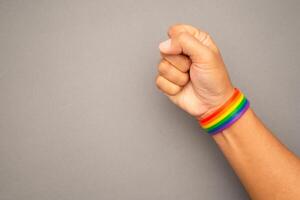 Top view of rainbow wristband in the wrist on a gray background photo