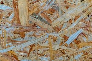 Natural wood shavings create a textured surface in a workshop setting during daylight hours photo