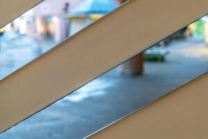 View of a colorful street through wooden slats during a quiet afternoon, showcasing vibrant architecture and a serene atmosphere photo