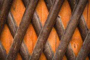 Wooden lattice design with diagonal slats creating a geometric pattern in a rustic setting photo
