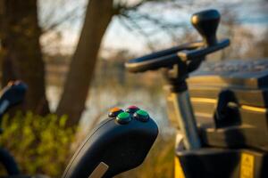 Construction equipment control panel near a serene lake during golden hour at sunset photo