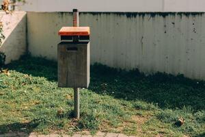 Modern waste bin situated on grassy area in urban park setting during daylight hours photo
