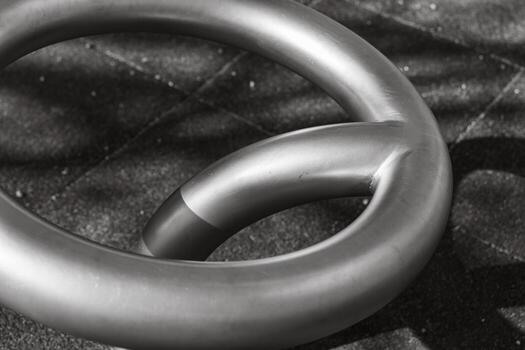 Metal loop resting on a textured surface in soft sunlight during morning hours photo