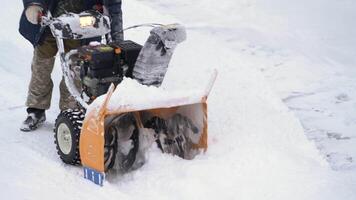 usando neve ventilador máquina, Claro neve a partir de entrada de automóveis depois de inverno ciclone. envolve jogando neve a partir de estrada. tarefa é para Claro neve depois de tempestade de neve. portátil tomada. kamchatka, Rússia - dezembro 28, 2023 video