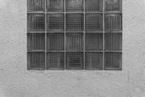 Glass block window on textured wall featuring unique patterns and natural light during the day photo