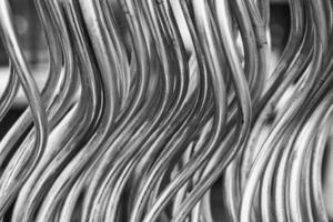 Curved metallic wires creating a dynamic pattern in black and white showcasing industrial design elements photo