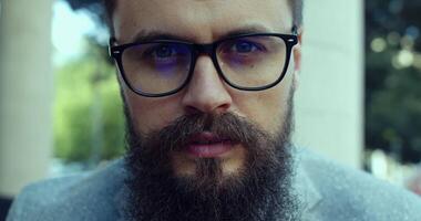 An Intense CloseUp Image Depicting a Bearded Man Wearing Glasses with Focused Expression video