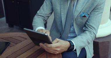 A stylish businessman uses a tablet in a modern office, showcasing professionalism and elegance video