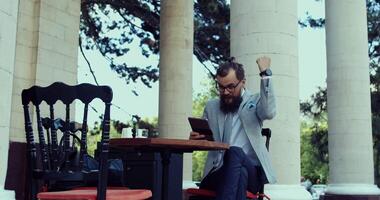 A Successful Businessman Joyfully Celebrating His Achievement While Using a Tablet Device video