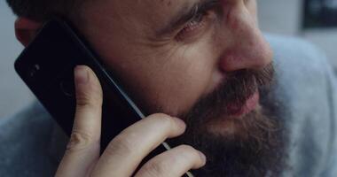 A man engaged in an authentic conversation while on the phone, immersed in an outdoor setting video