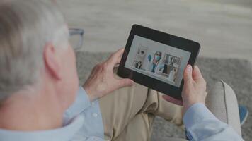 An elderly man in his 60s enjoys a call from the comfort of his home. He has grey hair and is casually dressed, reflecting a relaxed lifestyle during retirement. video
