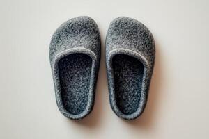 A single pair of gray slippers placed neatly on a white surface photo
