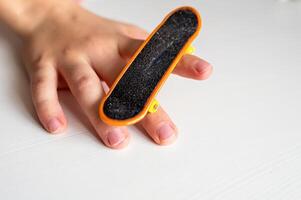 a person holding a fingerboard with their finger photo