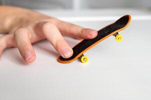 a hand holding a skateboard on a table photo