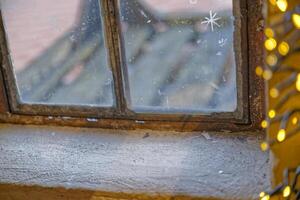 Frosty Window with Snowflake Patterns and Warm Lights photo