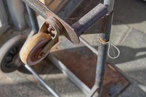 Close-Up of a Rusty Metal Cart with Worn Wheel photo