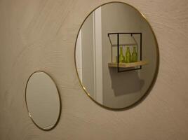Stylish Round Mirrors with Gold Frames and Green Bottles photo