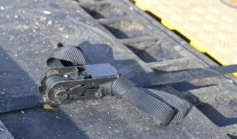 Close-Up of a Black Ratchet Strap on Textured Surface photo