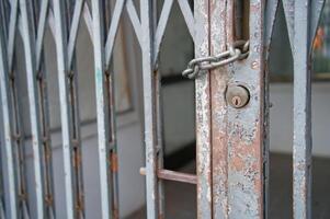 Rusty Locked Metal Gate with Chain and Padlock photo