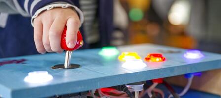 Child Playing with Colorful Joystick Control Panel photo