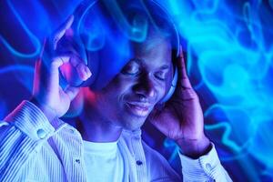 Positive black man enjoying music in headphones photo
