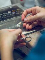 Anonymous dental technician working with artificial teeth photo