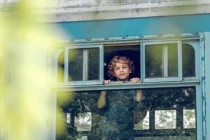 Smiling boy in train near window photo