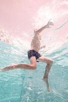 Underwater shot of anonymous boy swimming in pool photo