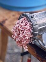 Meat grinder with mince on table in slaughterhouse photo