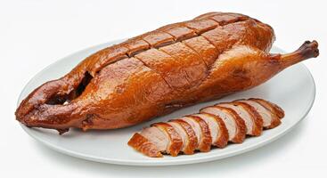 A large roast duck on a plate with sliced meat photo