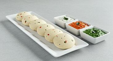 A plate with four small bowls of food on it photo