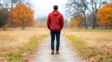 A person walking alone on a forest trail, surrounded by tall trees photo
